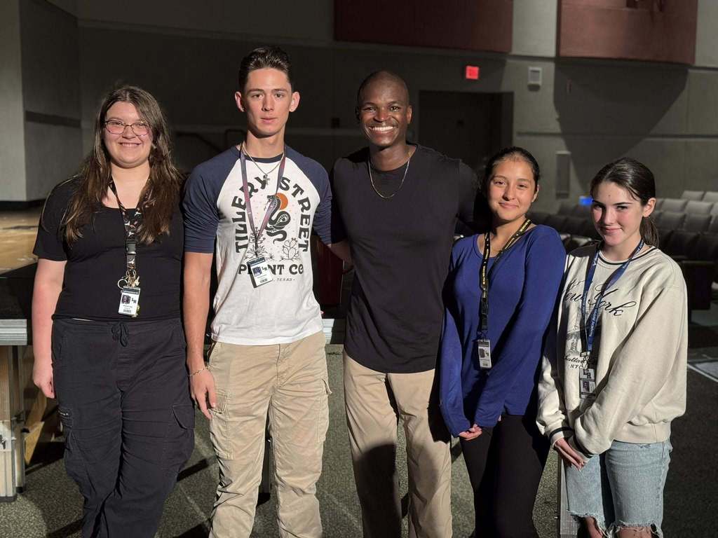 Smiling students with a special guest speaker.