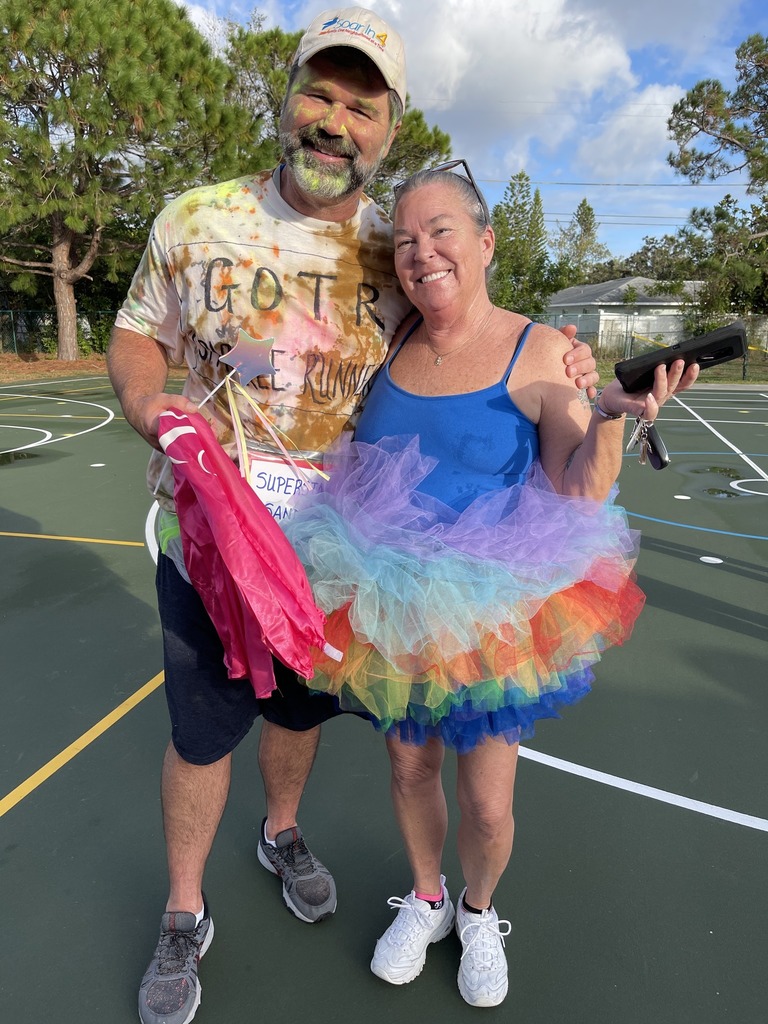 Two adults participating in a color run.