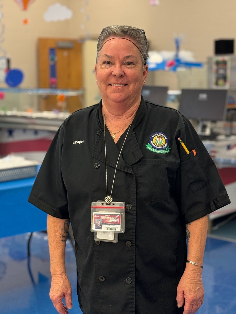 A cafeteria manager in a black uniform with a hairnet on.