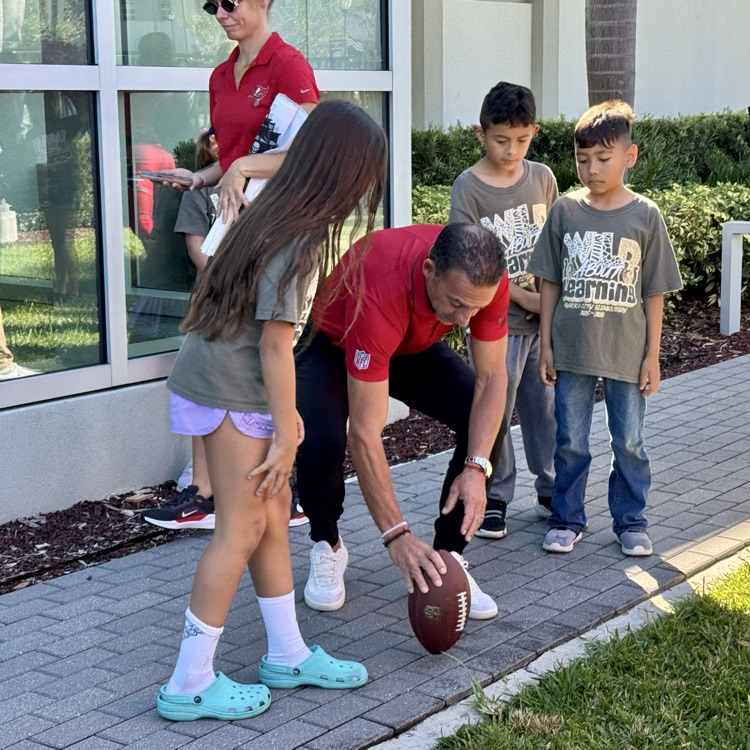 Super Bowl champion Martin Gramatica set up a football for a student to kick