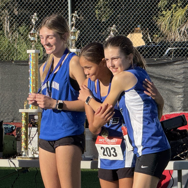 Middle school girls runners hug as awards are given after a cross country meet
