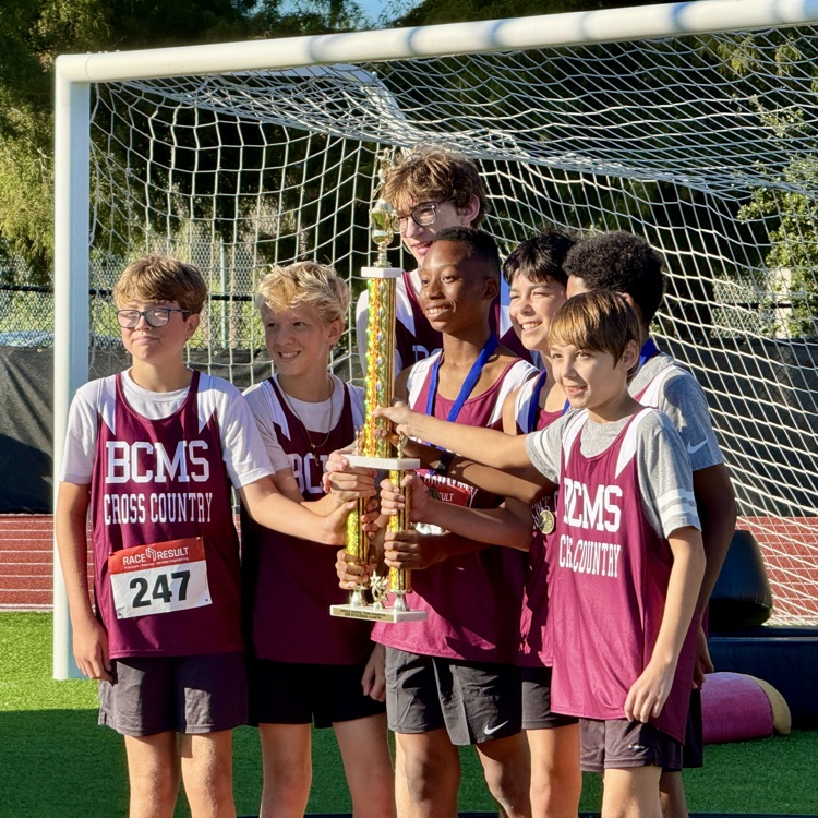 Middle school runners holding up a trophy