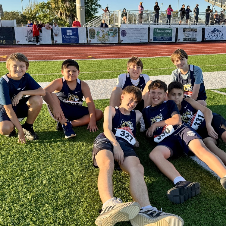 Boys middle school runners lay in the grass before their race takes place