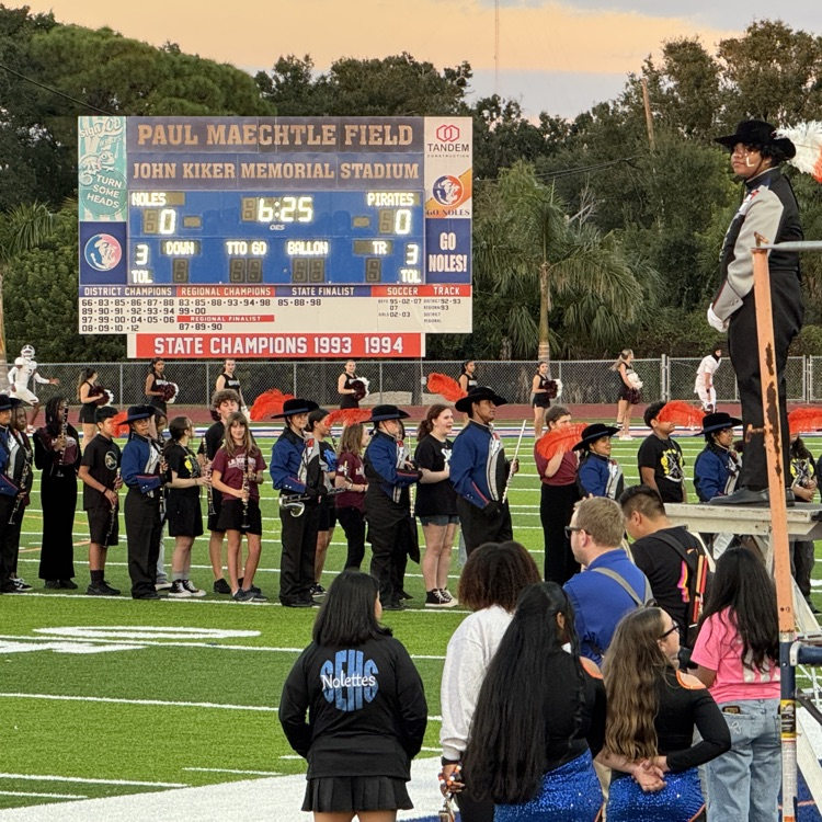 The southeast high drum major looks on as the marching band and their middle school guess stand on Paul Maechtle field