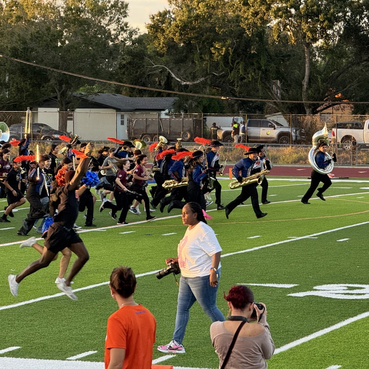 marching band performers, run onto the field at the start of their performance on Friday night