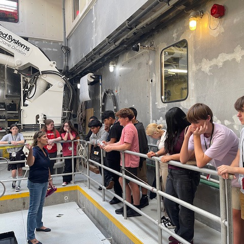 students listening to a speaker while aboard a research vessel on Florida’s West Coast