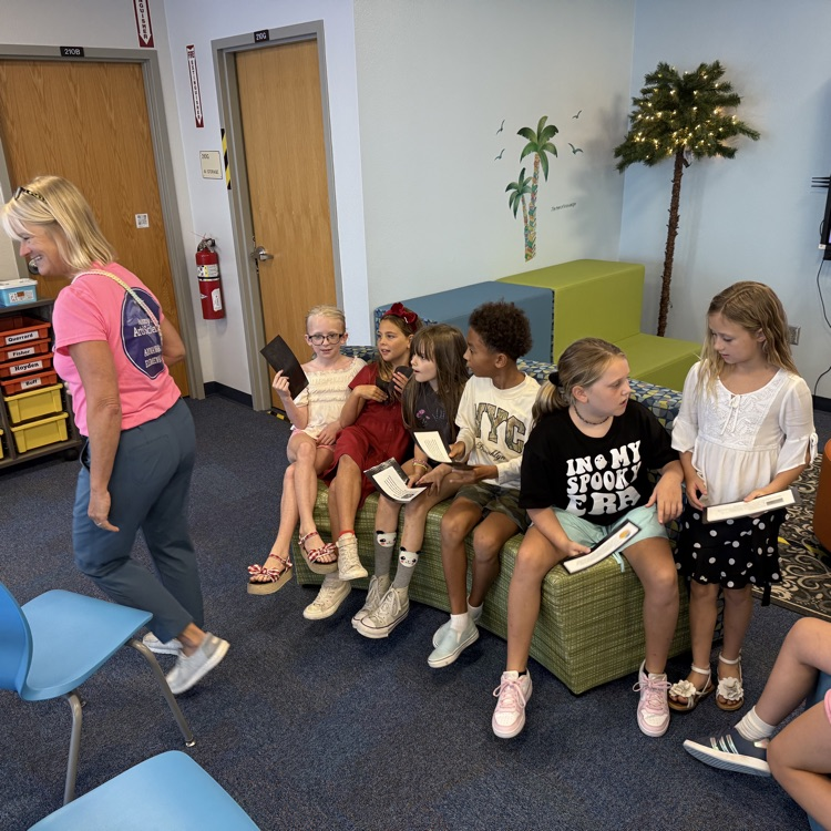 student sitting in a classroom with a teacher walking around