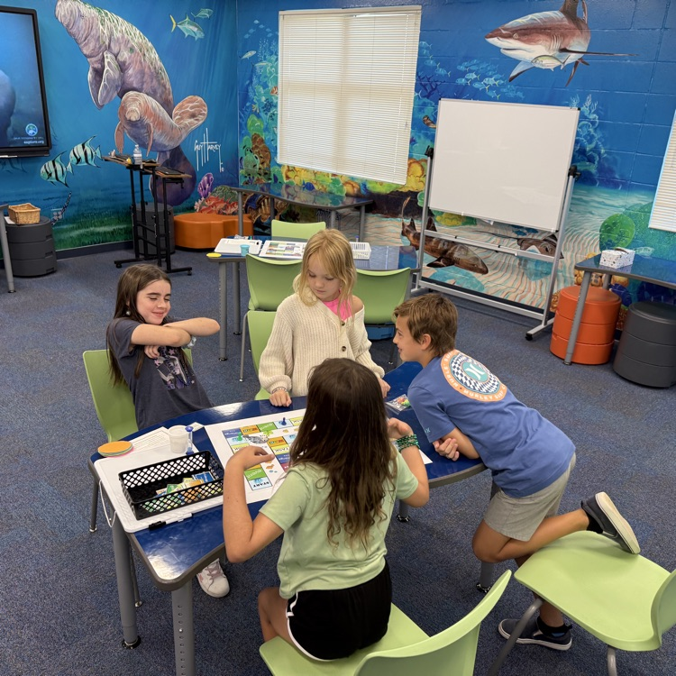 students collaborating in class with a beautiful guy Harvey mural painted on the wall