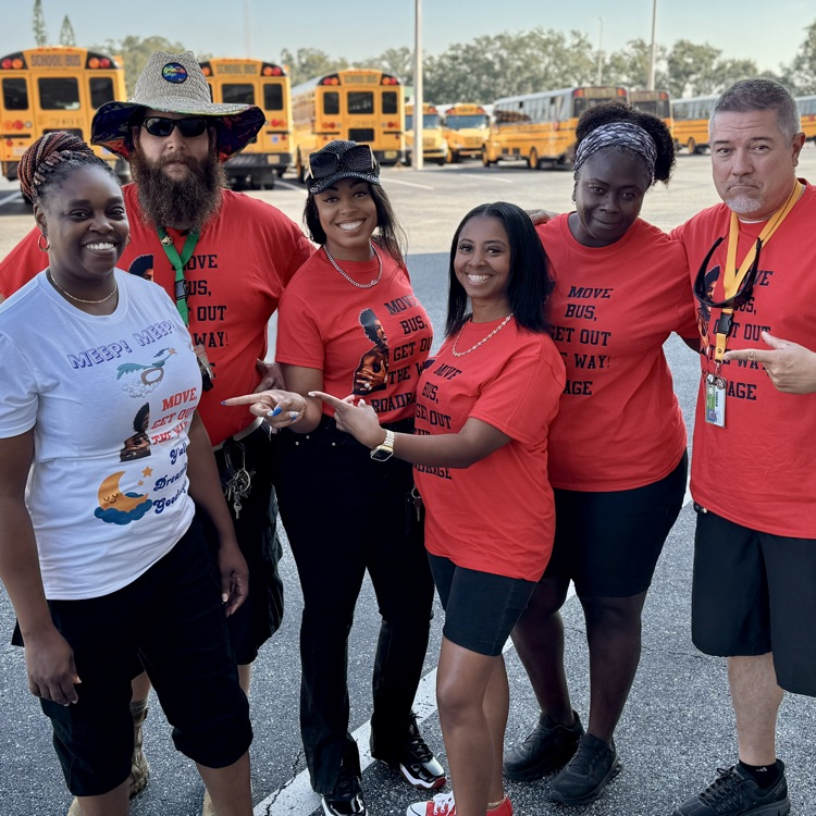 transportation employees pointing at their team name on the assistant directors T-shirt, and support