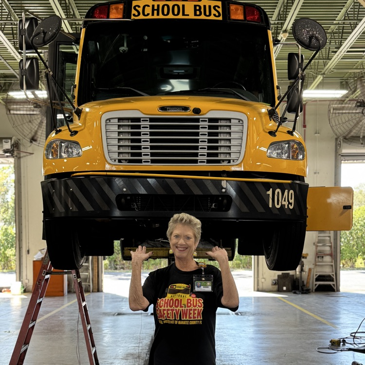 Long time employee, Linda Agresta holding up a school bus in the garage