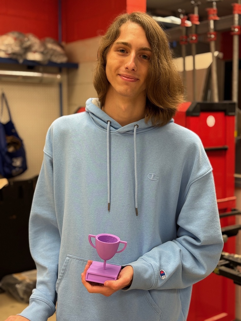 A student holding a purple 3D printed trophy prototype.