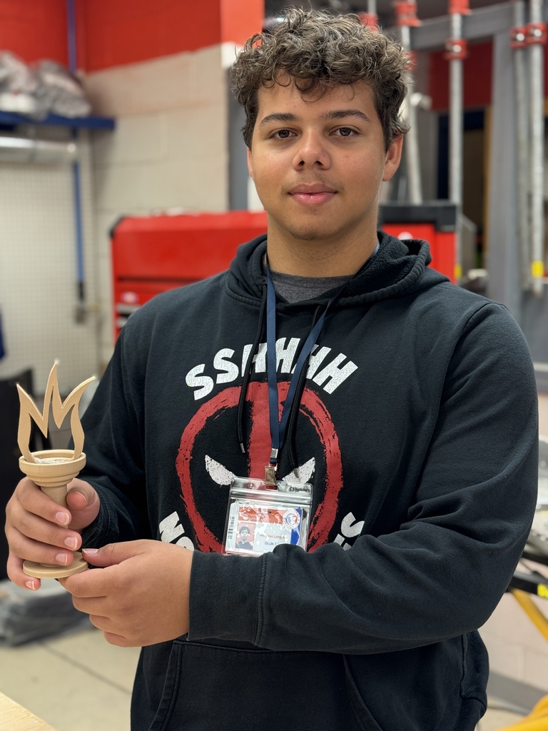 A student in a black sweatshirt holding his trophy prototype
