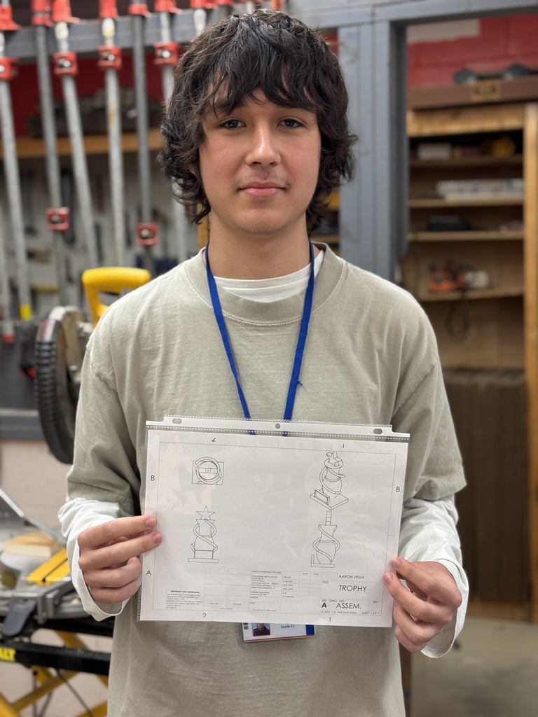 A teen holding up a model design for a trophy that was created