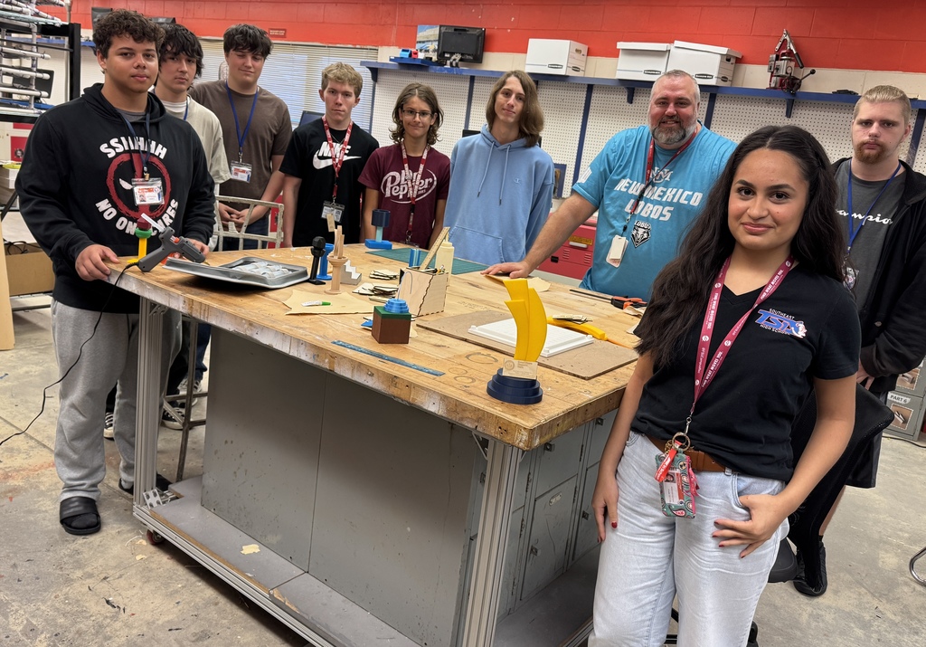 Technology students standing around a table and smiling at Southeast High
