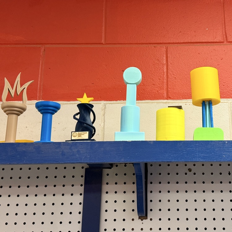 3-D printed trophies line and orange and blue wall