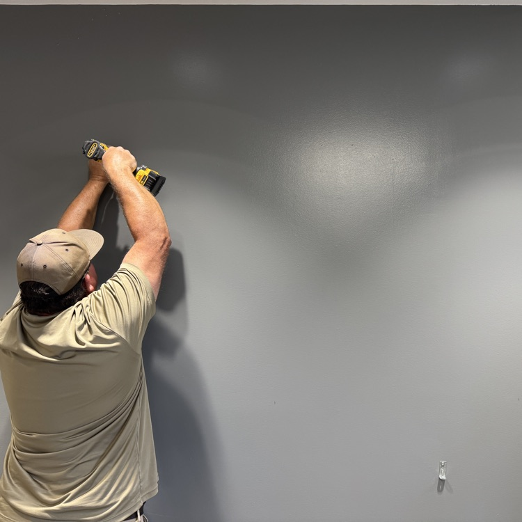 A worker nails something into the wall