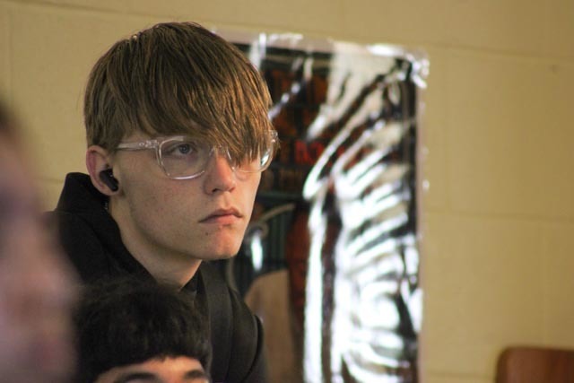 A high school student wearing an ear microphone.