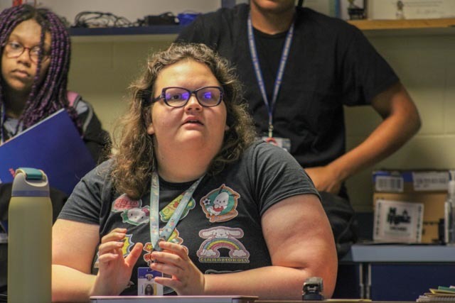 The executive editor of a student newspaper intently listens to a guest speaker.
