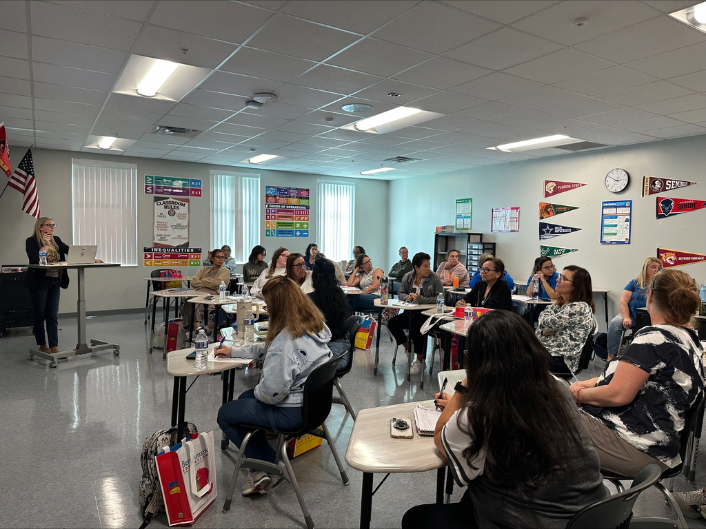 Teachers sitting in a classroom during a professional development seminar.