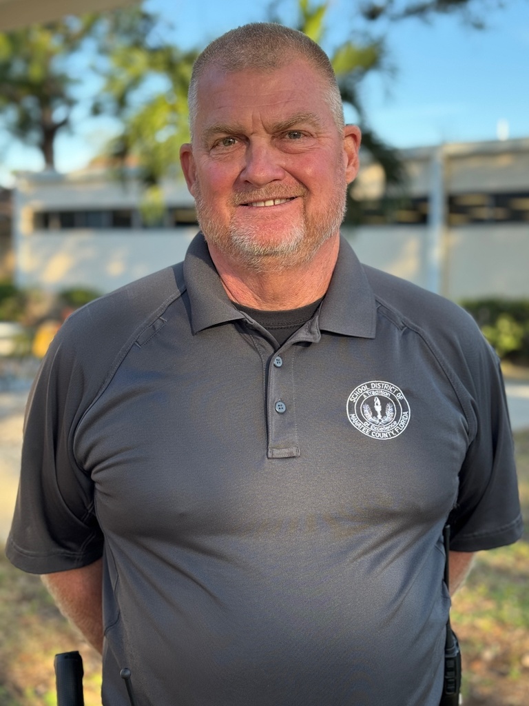A school safety guardian smiling on a school campus.