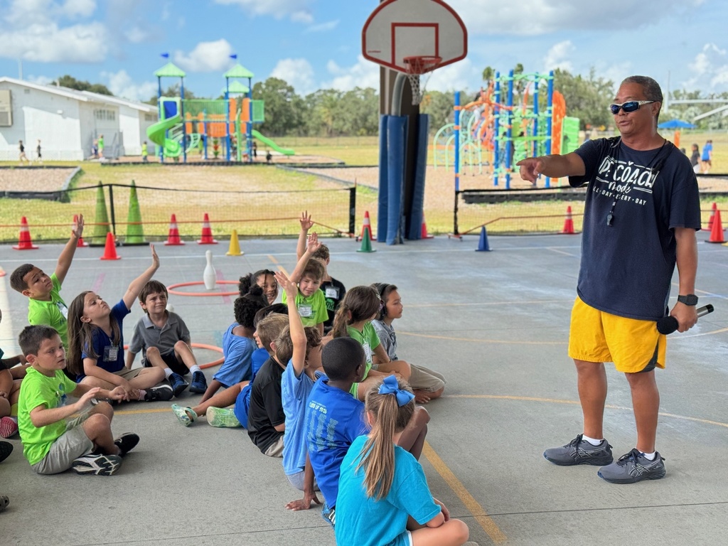 A PE teacher points to a student under the covered basketball courts at school.