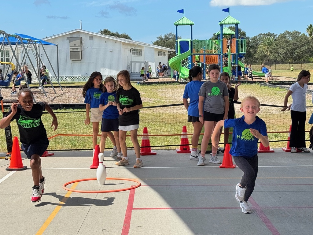A child smiling while running a relay at PE