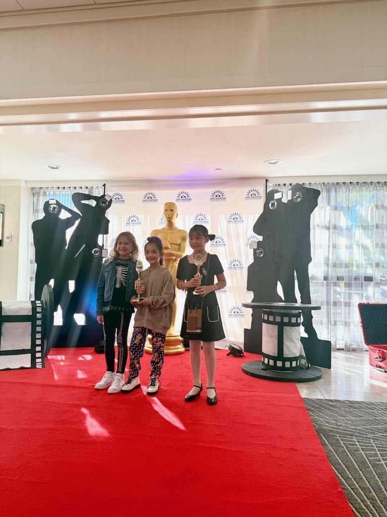Young filmmakers walk a red carpet.