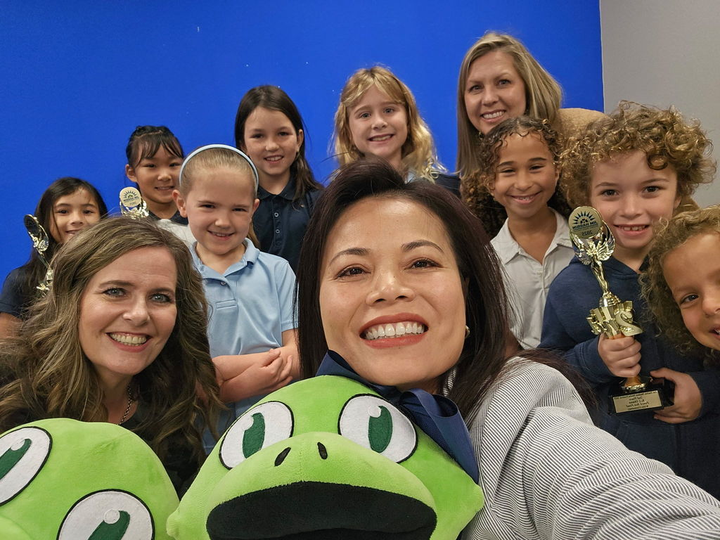School staff and students take a smiling selfie.