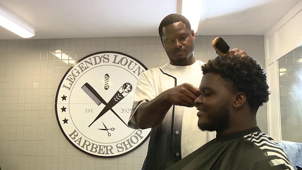A barber cuts hair inside a locker room barber shop at Southeast High. 