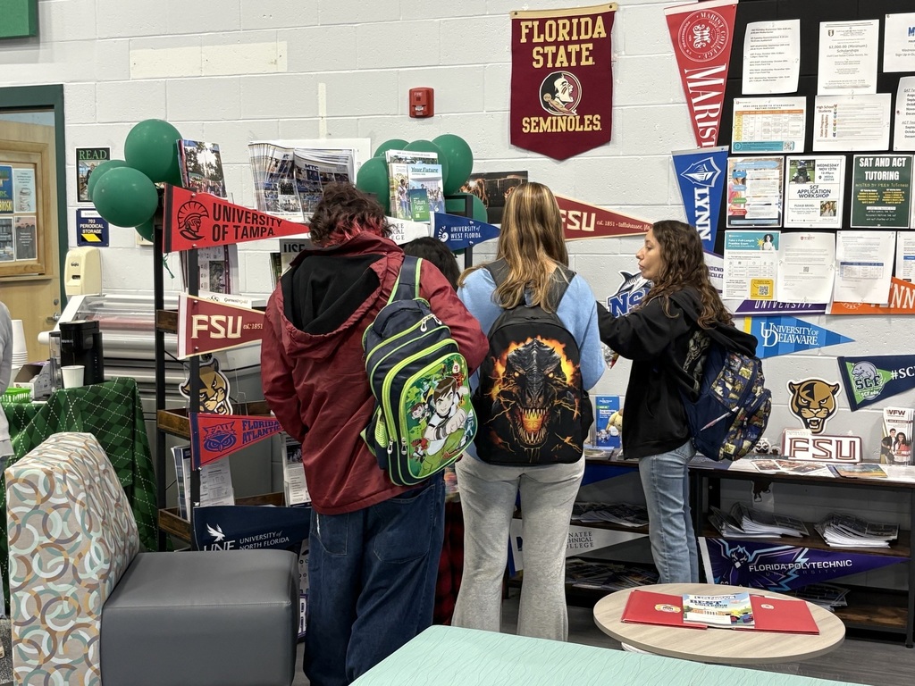 students looking at displays of college information at school.