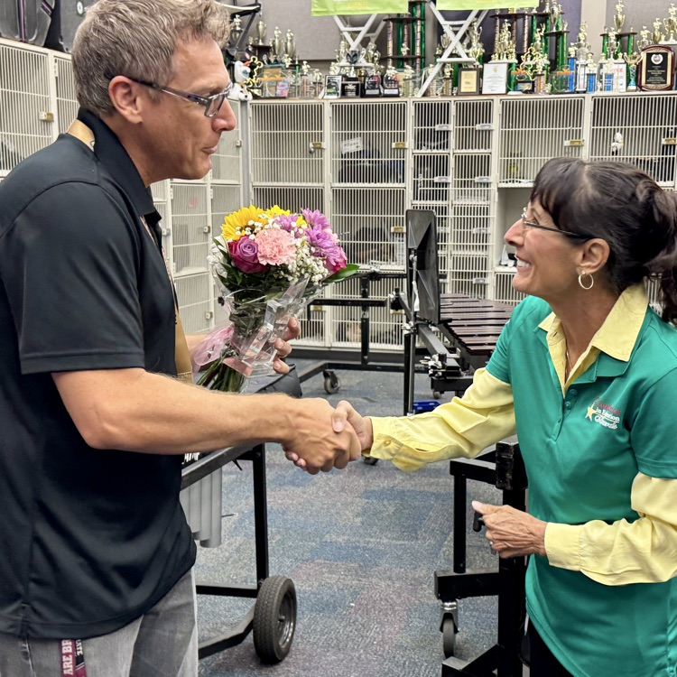 A school board Chere shakes a hand of a teacher of the year finalist