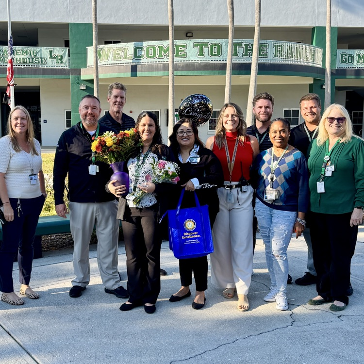 School staff congratulate their colleague, who was just surprised as employee of the year finalist