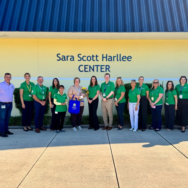 A group of school district leaders congratulate a support employee of the year final