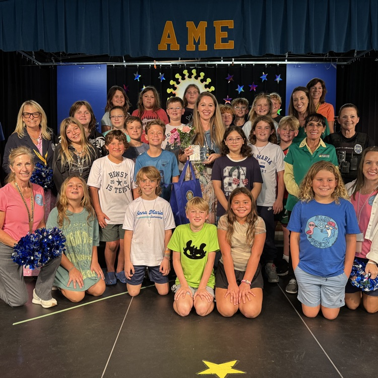 A teacher of the year finalist and her studio smile for a photo
