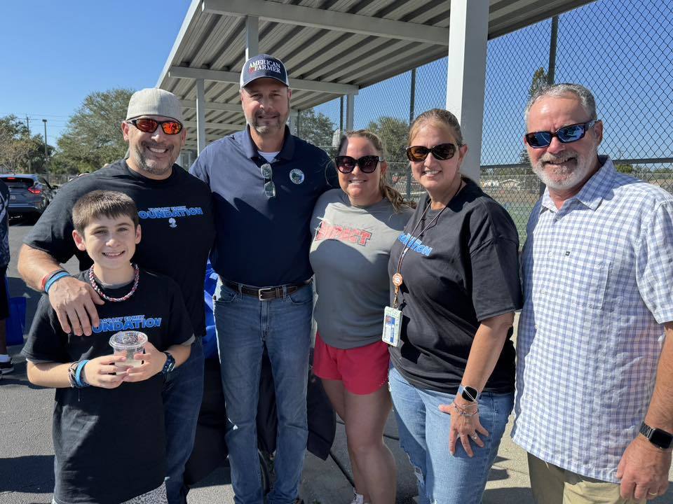 Volunteers take a quick break to smile for a photo during the Taggart Family Foundation Turkey Giveaway.