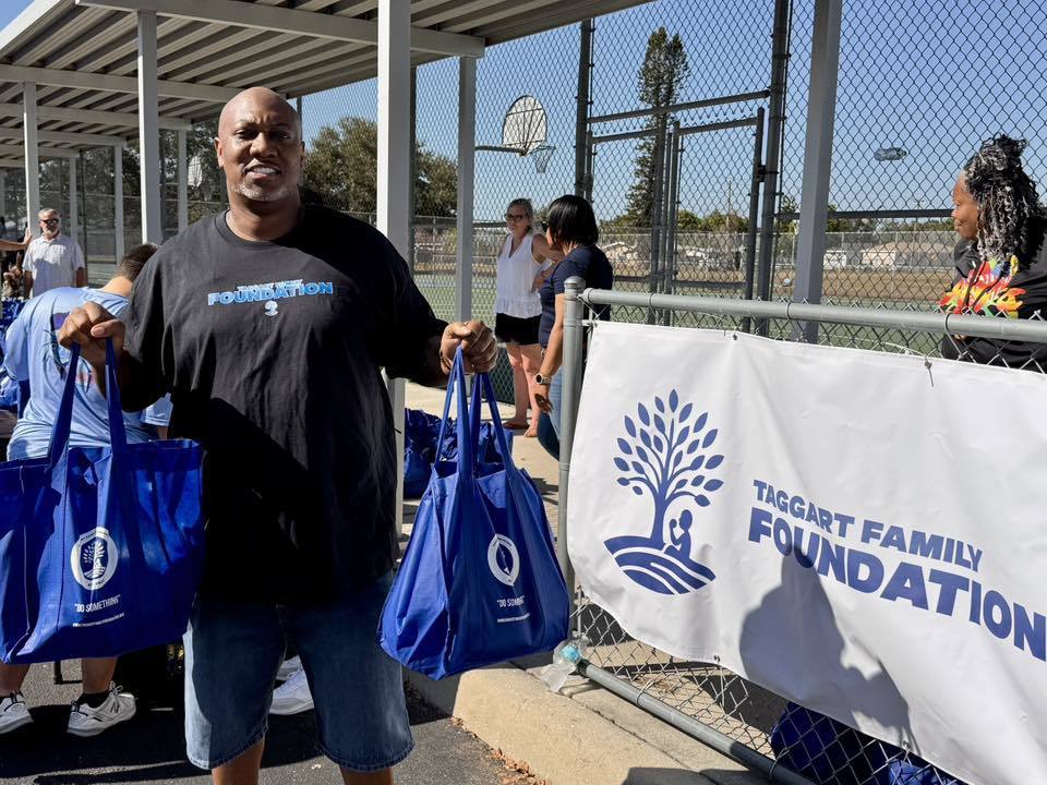 A volunteer passes out food bags during the Taggart Family Foundation turkey giveaway.