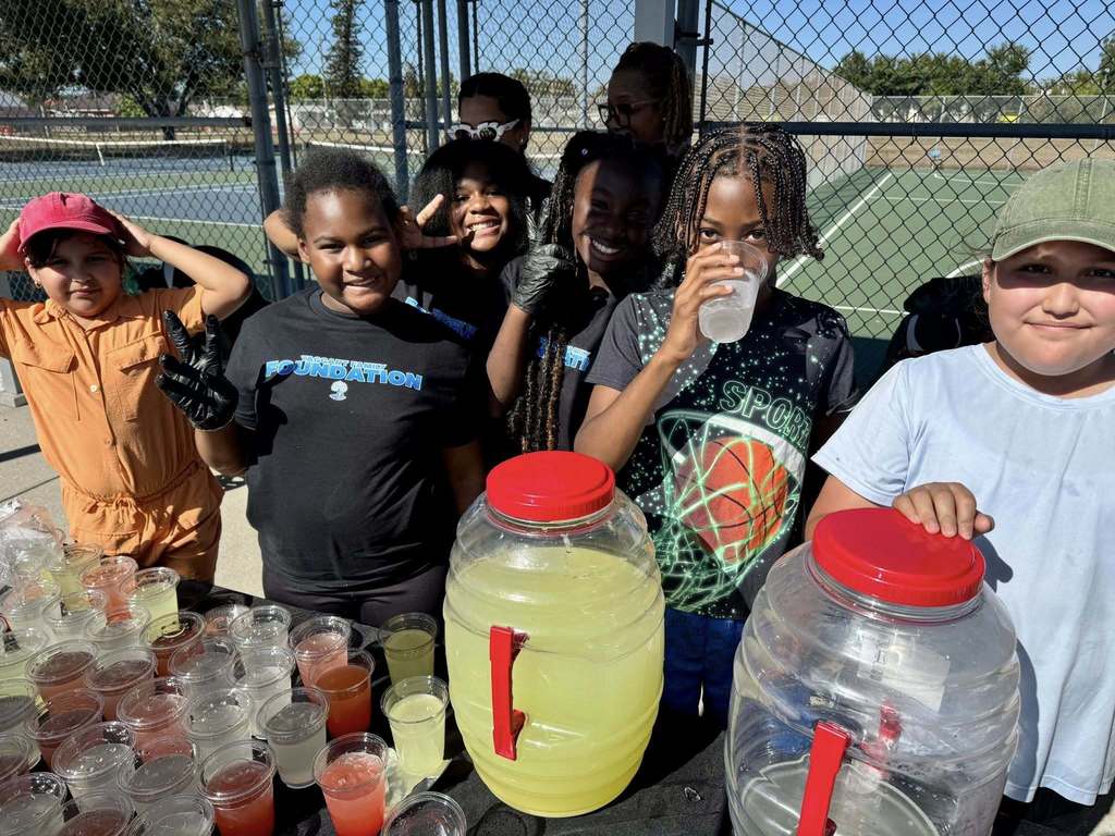 Student volunteers filling cups with juice for a turkey giveaway event