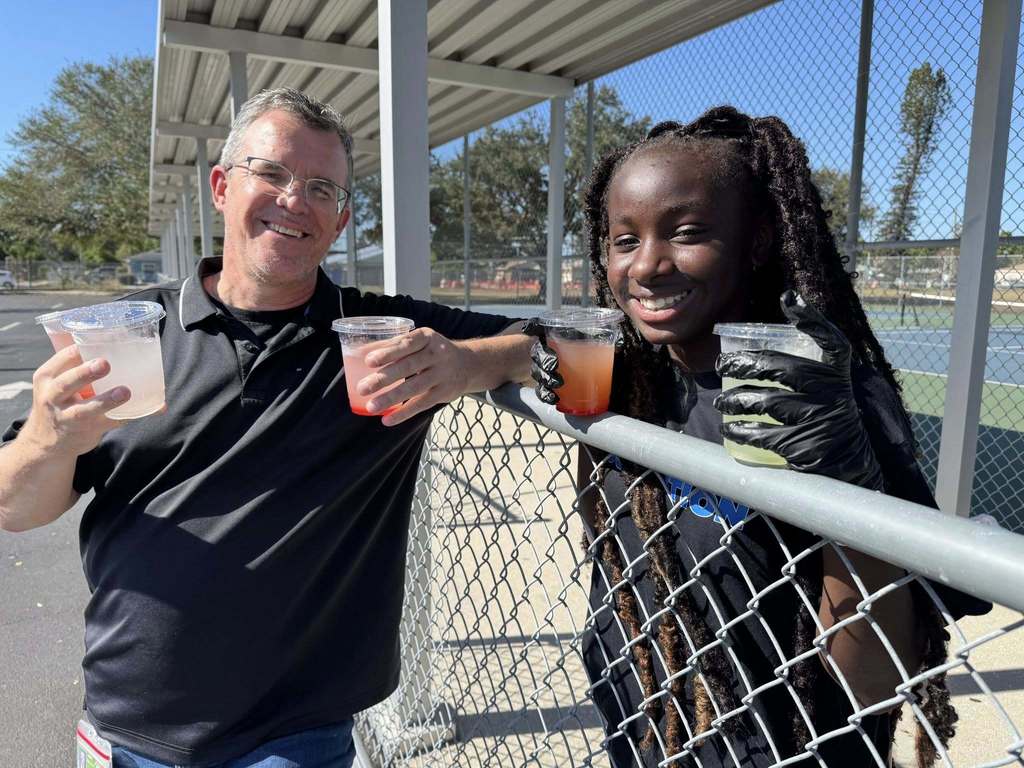 School Board member Charlie Kennedy volunteers with a student during a turkey giveaway.