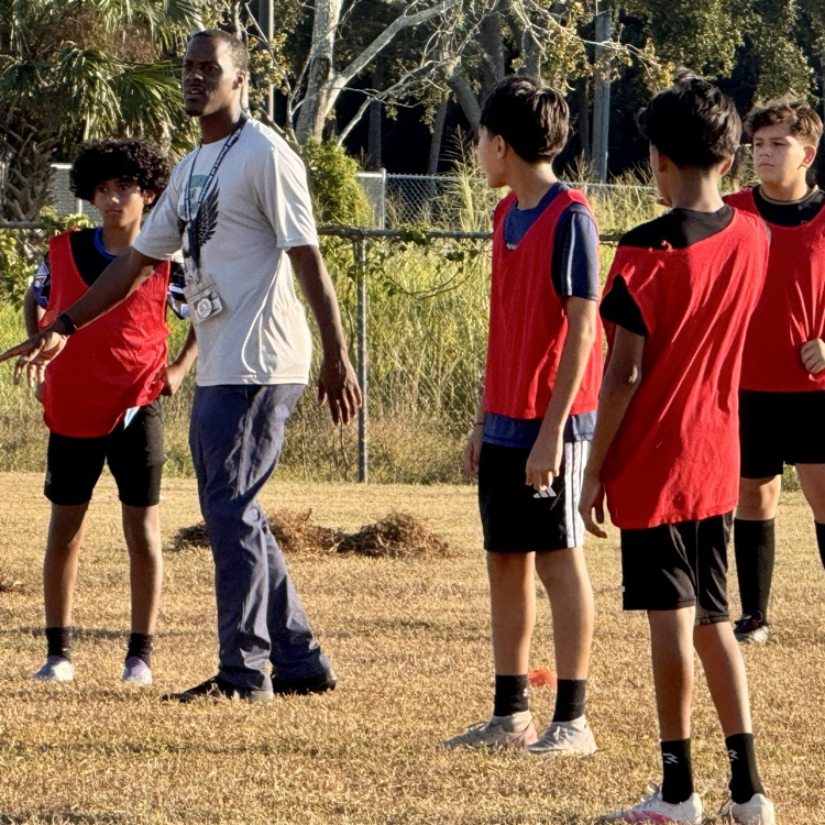 A soccer coach instructing students after school