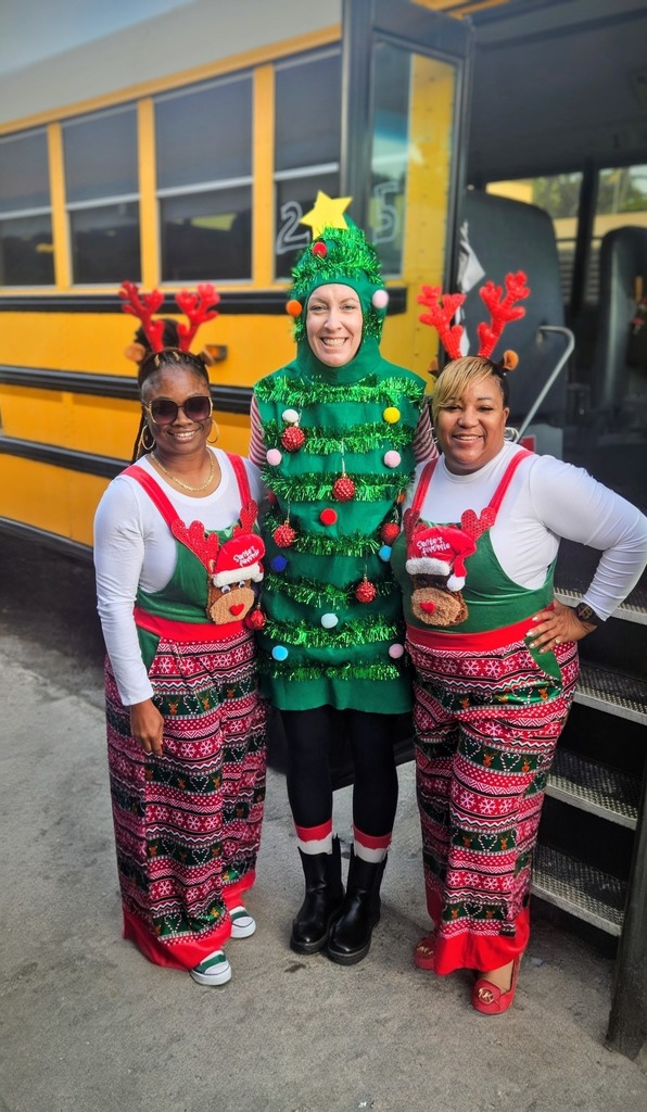 A school principal dressed as a Christmas Tree and two bus drivers/aides dressed as reindeer.