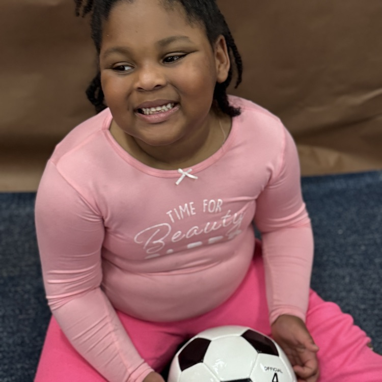 A girl smiling after seeing a soccer ball for Christmas