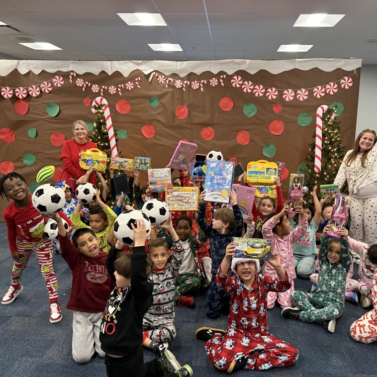 A class of young students holds their toys up in the air