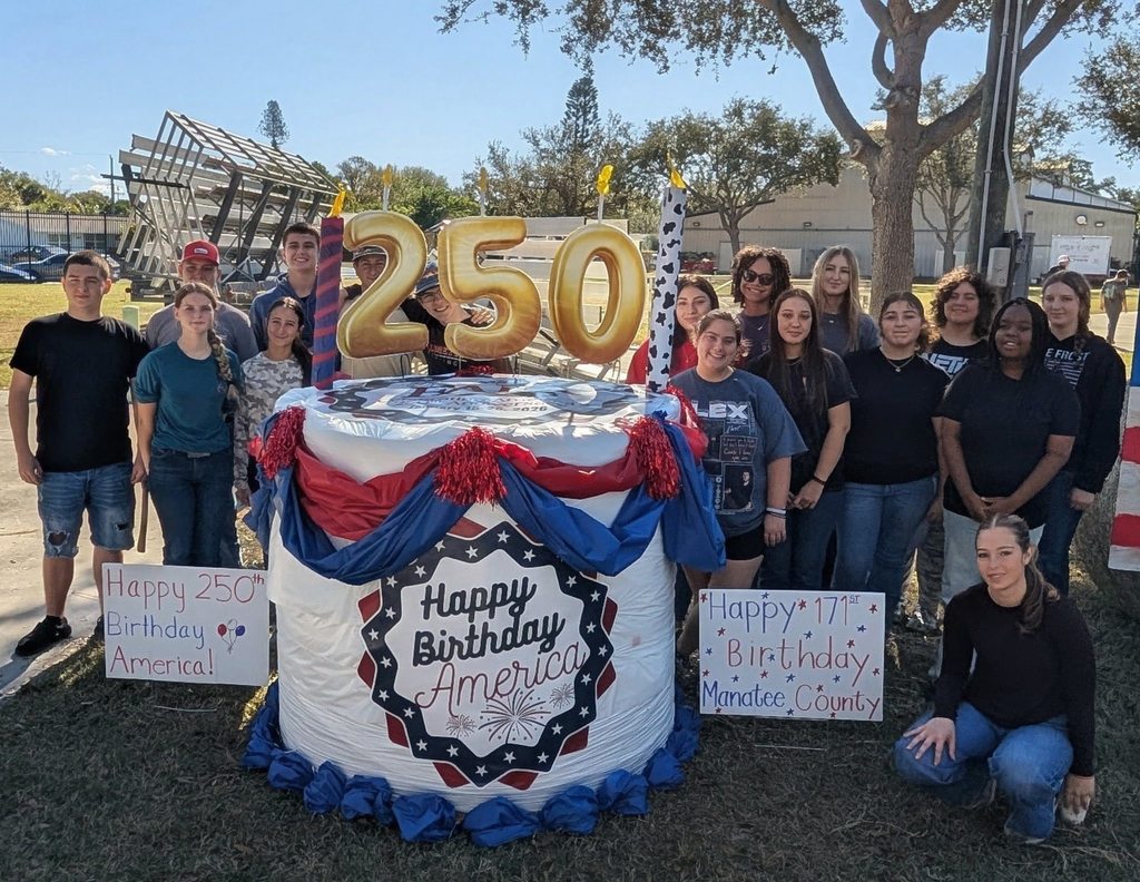 Students standing next to a decorated bale of hay which reads, 250: Happy Birthday, America