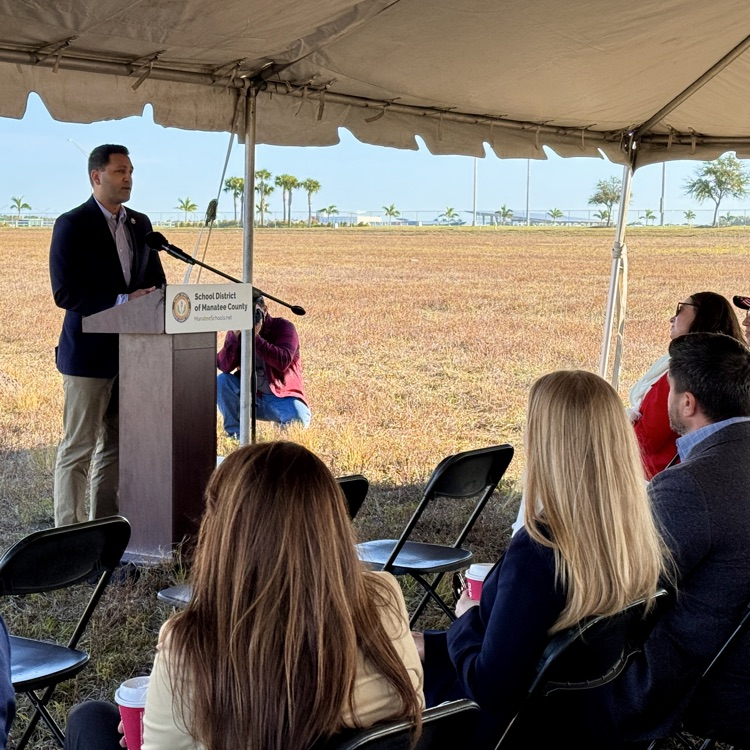 A county commissioner speaks during a school groundbreaking