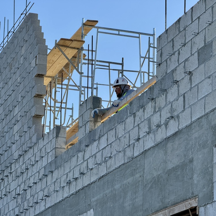 A construction worker overlooks the site of a school being built