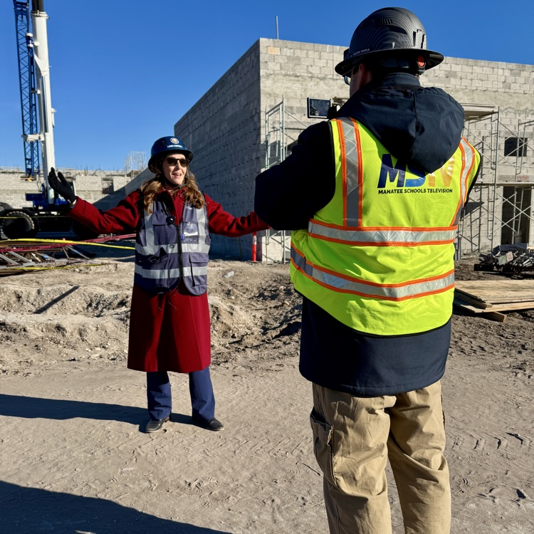 an elementary school principal getting interviewed at a construction site