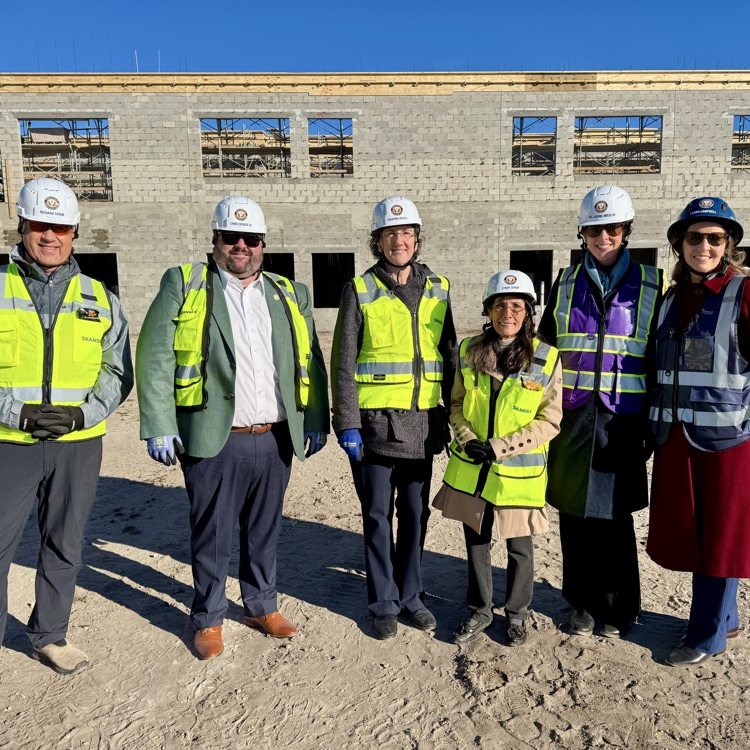 School board members wearing hard hats and construction vest