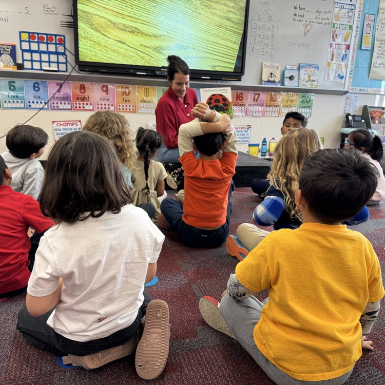 A guest reader looking at students
