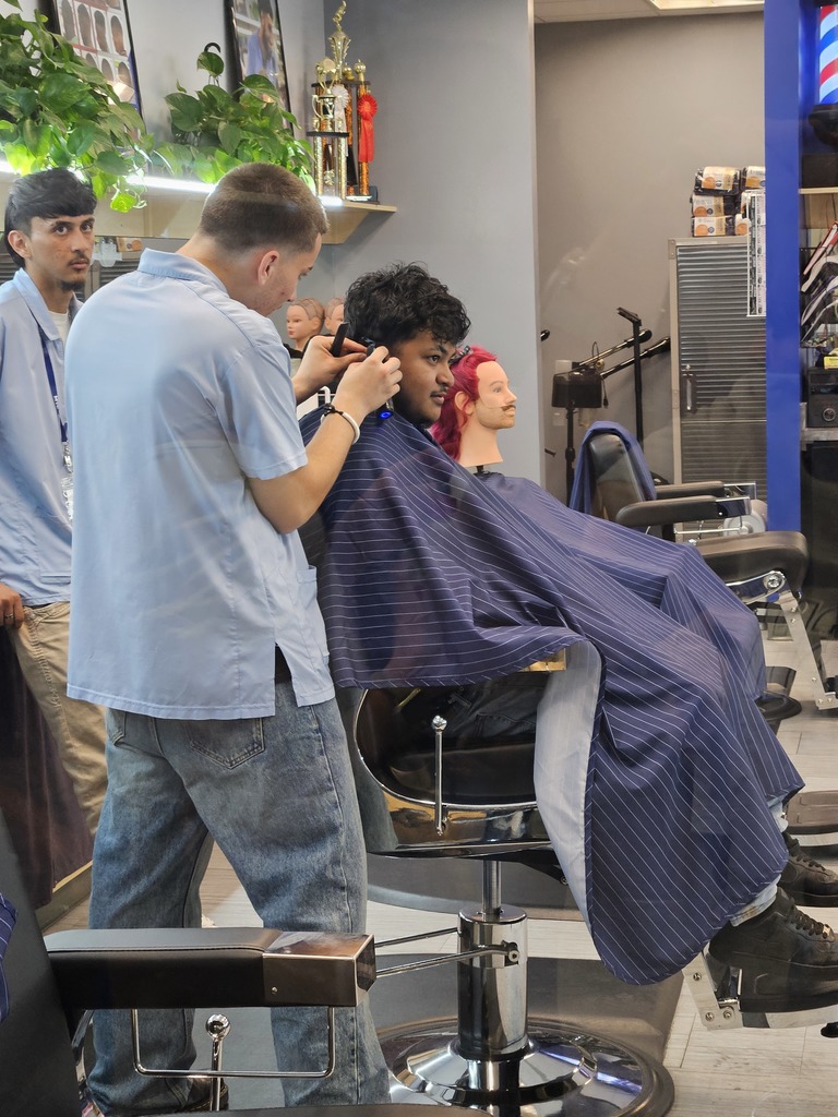 A student receives a haircut from an MTC student in the barbering program.