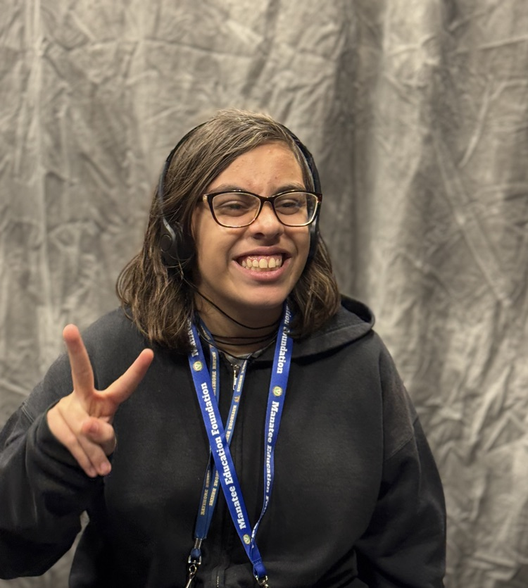 A portrait of a young woman giving a peace sign